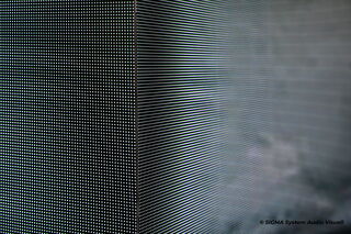 Das Foto zeigt eine Ecke bei der sich zwei LED-Displays treffen. Die Detailaufnahme verdeutlicht die einzelnen "LED-Punkte" die im kleinen Abstand nebeneinander angebracht wurden. Die Installation lässt im Übergang der Ecke fast kein Unterschied erkennen.