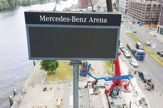 Ein LED-Bildboard von Unilumin an einer vielbefahrenen Straße in Berlin. Das Billboard gehört zur Mercedes-Benz Arena in Berlin, gut sichtbar durch den Markennamen über dem LED-Display erkennbar.