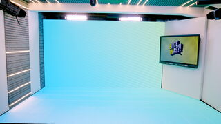 Helles, modernes Aufnahmestudio. Die schallisolierten Wände sind mit grauem Filz verkleidet, während ein LED-Boden und eine LED-Rückwand in Türkisblau leuchten.